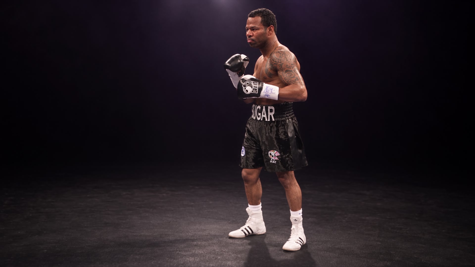 Sugar Shane Mosley in fight attire under a single spotlight